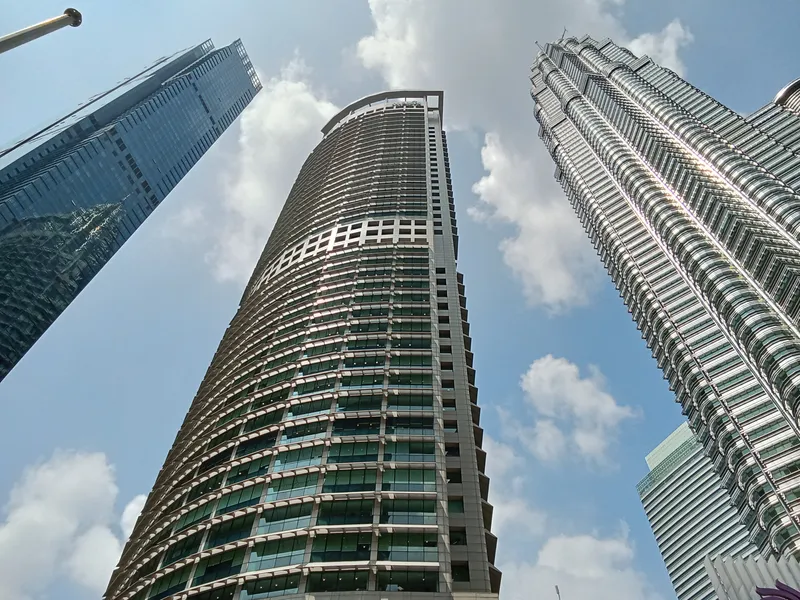 Menara Maxis curved fa&ccedil;ade with the Petronas Twin Towers alongside